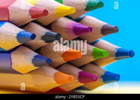 This image shows a close-up of the tips of several colored pencils in various hues, including yellow, green, blue, red, and purple. Stock Photo