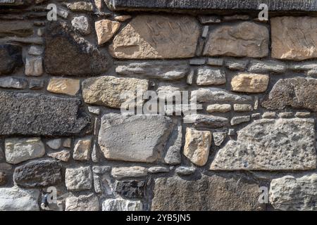 Full frame abstract texture background of a rugged stone wall, with copy space Stock Photo