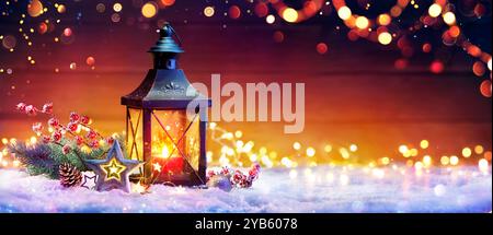 Christmas Lantern With Fir Branch and Decoration On Snowy Table - Abstract Bokeh Lights On Background Stock Photo