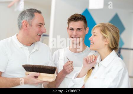 portrait of painter talking to apprentices Stock Photo
