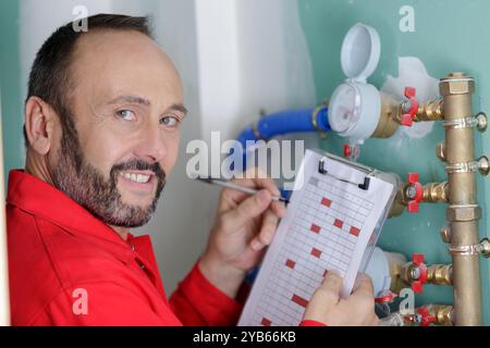 technician reading the water meter to check consumption Stock Photo