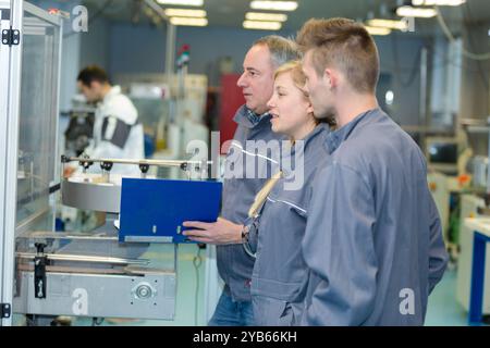 apprentice and engineer using computer controlled cutting machine Stock Photo