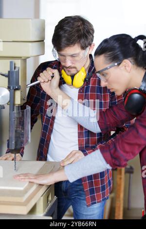 woman using bench drill under supervision Stock Photo