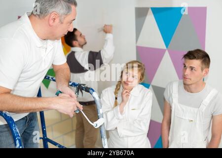 portrait of a mature painter with apprentices Stock Photo