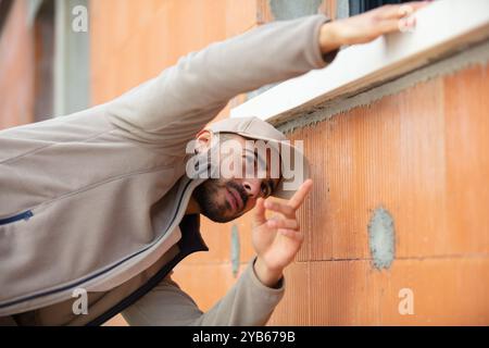 builder checking brick wall with spirit level Stock Photo
