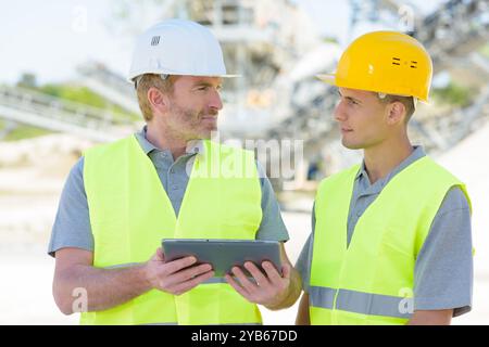 two workers on a construction site using a tablet Stock Photo