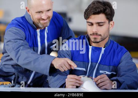 Row Line Enginering In a beverage factory line two engineers inspect product bottles on the ...