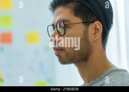 Asian man  prompt engineer develop coding app with software data sitting in front of computer monitor at office Stock Photo