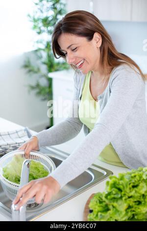 girl clean lettuce under water with splash Stock Photo