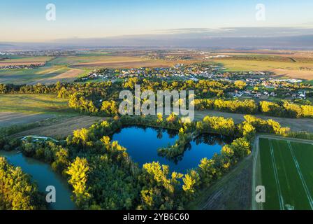 Beautiful sunset over Slovakia country with lake, field,  village and forest. Aerial view at sunset. Hruby Sur Stock Photo