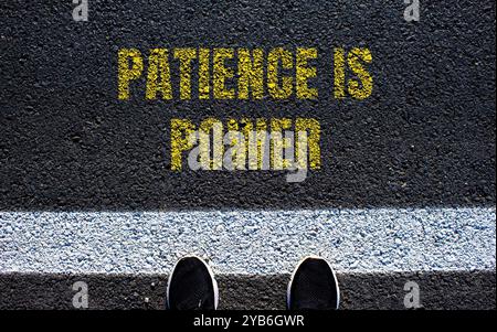 Patience is power message written on asphalt road. Conceptual patience is power symbol. Copy space. Stock Photo