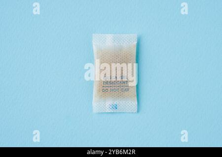 Silica gel or desiccant in paper bag isolated on blue background Stock Photo