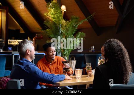 African and Black colleagues having wine and chatting together Stock Photo