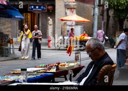 Xi'an, China - September 21 2024: Man sell souvenirs in the Shuyuanmen ancient cultural street in Xi'an old town near the Yongningmen city gate with t Stock Photo