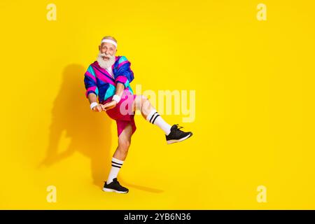 Full length photo of cheerful positive mature guy dressed retro sport jacket dancing emtpy space isolated yellow color background Stock Photo