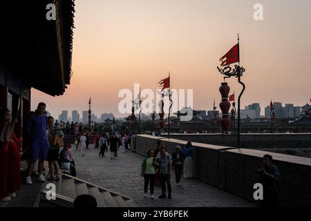 Xi'an, China - September 23 2024: People enjoy the sunset over Xi'an old town from the Yongningmen gate in the city ancient wall in Shaanxi in central Stock Photo