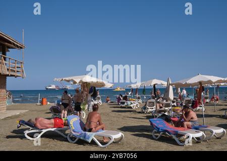 Sunbathers enjoying the late summer sun on Finikoudes beach in larnaca, Cyprus Stock Photo