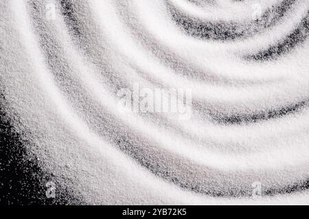 Finely ground stone white rock salt texture on black background, top view Stock Photo