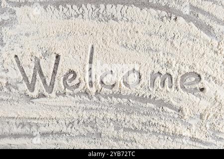 Grey cooking background of spilled wheat flour on stone background with text Welcome Stock Photo