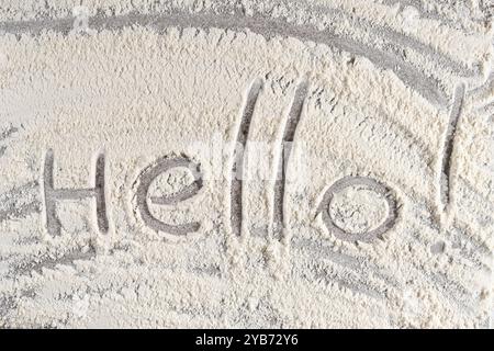 Grey cooking background of spilled wheat flour on stone background with text Hello. Stock Photo