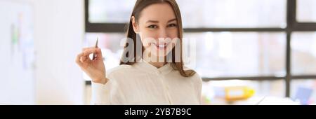 Young woman smiles holding investigation papers and pen Stock Photo
