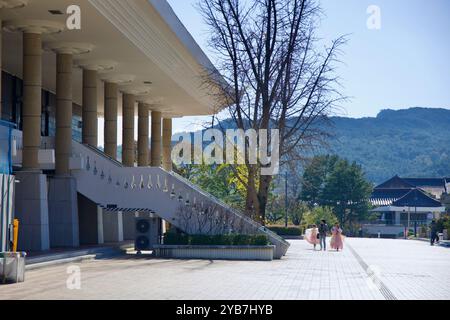 Gyeongju, South Korea - November 11th, 2023: Visitors dressed in traditional Hanbok walk past the main entrance of Gyeongju National Museum, with the Stock Photo