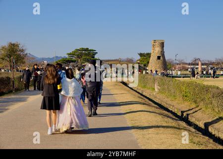 Gyeongju City, South Korea - November 11th, 2023: Visitors stroll along a busy pathway leading to the historic Cheomseongdae Observatory. The surround Stock Photo