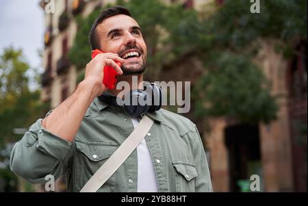 Cheerful man outdoors walking in the city speaking on the phone. Stock Photo