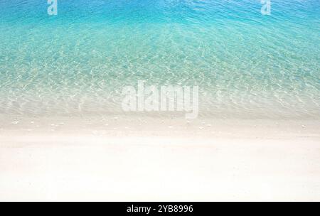 White sandy beach with transparent water on seashore as summer background Stock Photo