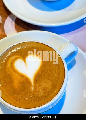 Heart-shaped foam in cup of coffee. Stock Photo