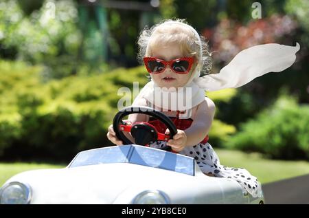 A young girl driving a toy car Stock Photo Alamy