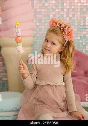 Portrait of a cute little girl with cotton candy in her hand in the studio Stock Photo