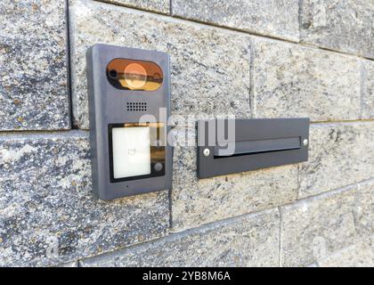 Modern intercom and mailbox on stone wall Stock Photo