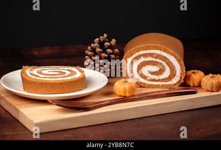 Fall Pumpkin Roll On a Plate With Dark Background Mini Pumpkins and Pinecone Stock Photo