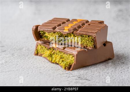 Dubai Chocolate bar with green kadayif and peanut butter on white stone table Stock Photo