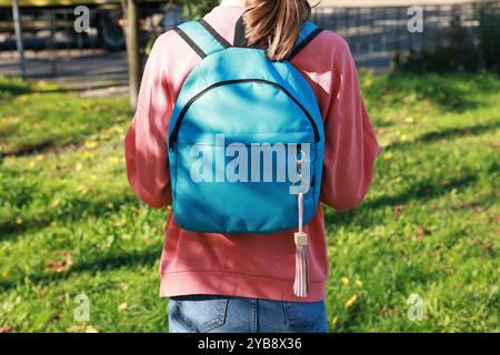 Woman with pink leather keychain on her backpack outdoors, closeup Stock Photo