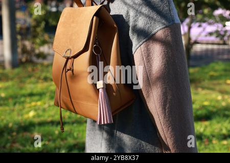 Woman with pink leather keychain on her backpack outdoors, closeup Stock Photo