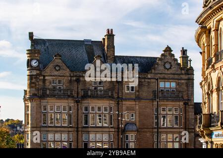 A historic building with intricate architectural details, featuring a clock tower and multiple windows. The structure is made of stone and has a slate Stock Photo