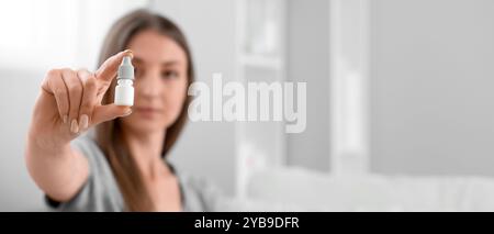 Young woman with eye drops at home. Banner for design Stock Photo