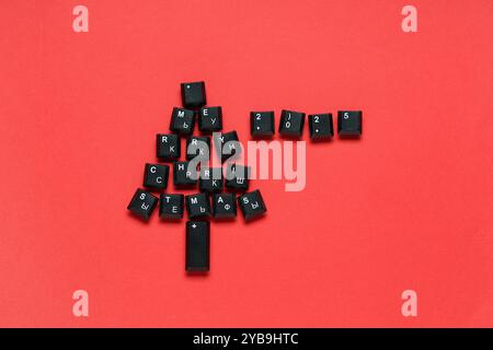 Christmas tree made of black computer keys on red background Stock Photo