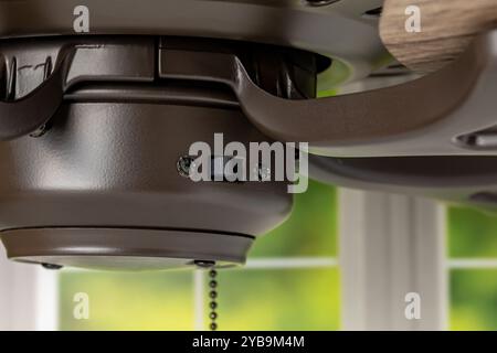 Direction switch on ceiling fan. Indoor heating and cooling savings, energy conservation, and ceiling fan blade rotation concept. Stock Photo