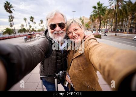 Portrait of happy Caucasian mature tourist couple taking selfie together. Retired people in love Stock Photo