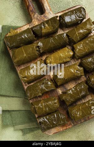 Dolma, minced meat with rice, in grape leaves, minced meat rolls, on a chopping board, top view, no people Stock Photo