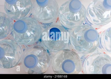 Top view of bottles of water with an odd one with a dark blue cap. Stock Photo