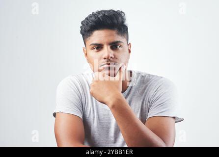 Indian man, portrait and fashion with casual style, tshirt or hairstyle in studio on a white background. Young, male person or handsome gen z model Stock Photo