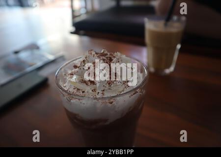 Iced chocolate with whipped cream on wooden table Stock Photo