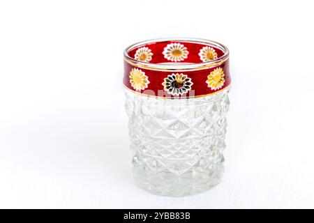 A vintage crystal glass cup with decorated rim, isolated on a white background. Stock Photo