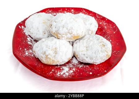 Kourabiedes, Greek butter cookies, on a red plate, isolated in a white background. Stock Photo