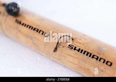 Lefkada, Greece- 10.04.2024. Close up of a fishing rod by the Japanese company Shimano showing the brand name together with a fishing hook and a lead Stock Photo