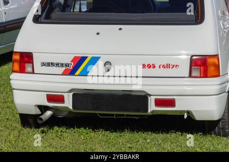 White peugeot 205 rallye parked on grass, its iconic design and rally heritage evident in its lines and badging Stock Photo